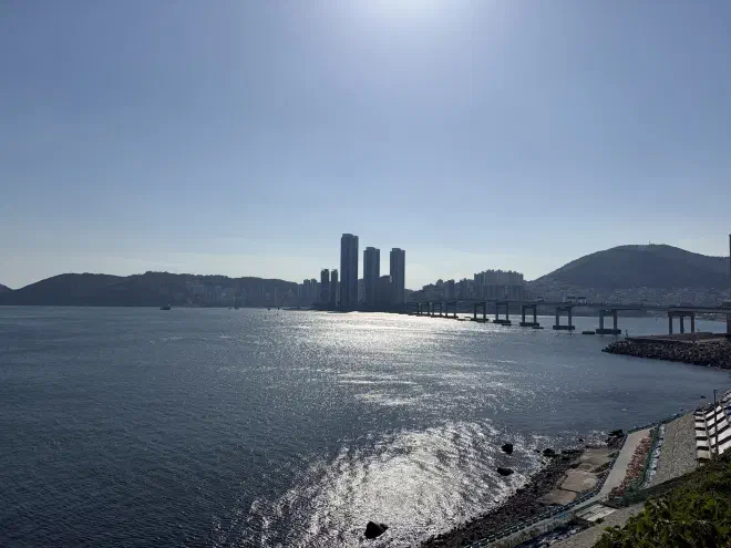 A calm ocean with high rise buildings in the background