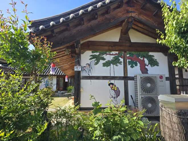 Modern meets tradition A traditional korean building with two air-conditioners has a tree and woman in a swing painted on its side
