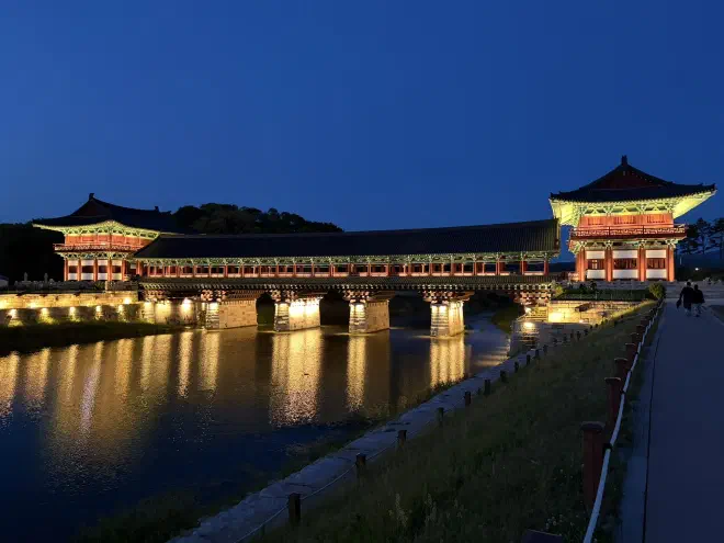 Woljeonggyo Bridge during blue hour A traditional wooden bridge at night with lights illuminating the underside of the structure