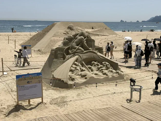 Sand art of Avatar: The Way of Water A sand sculpture with a representation of a character from Avatar: The Way of Water with the ocean in the background