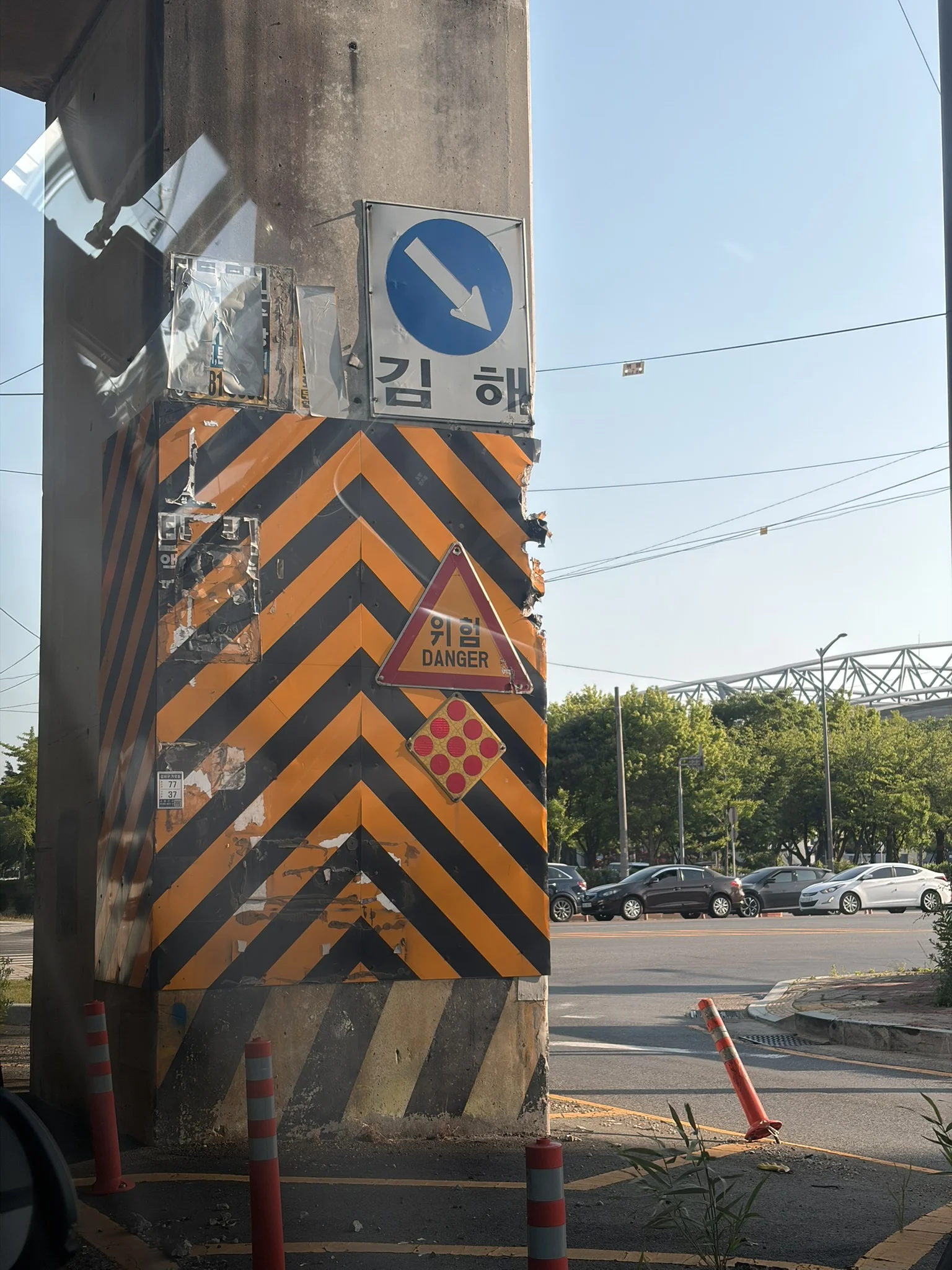 How many warning lights do you need? A giant concrete pillar wrapped in a giant orange chevron, with a reflective diamond, and a danger sign, with multiple chunks taken out of it