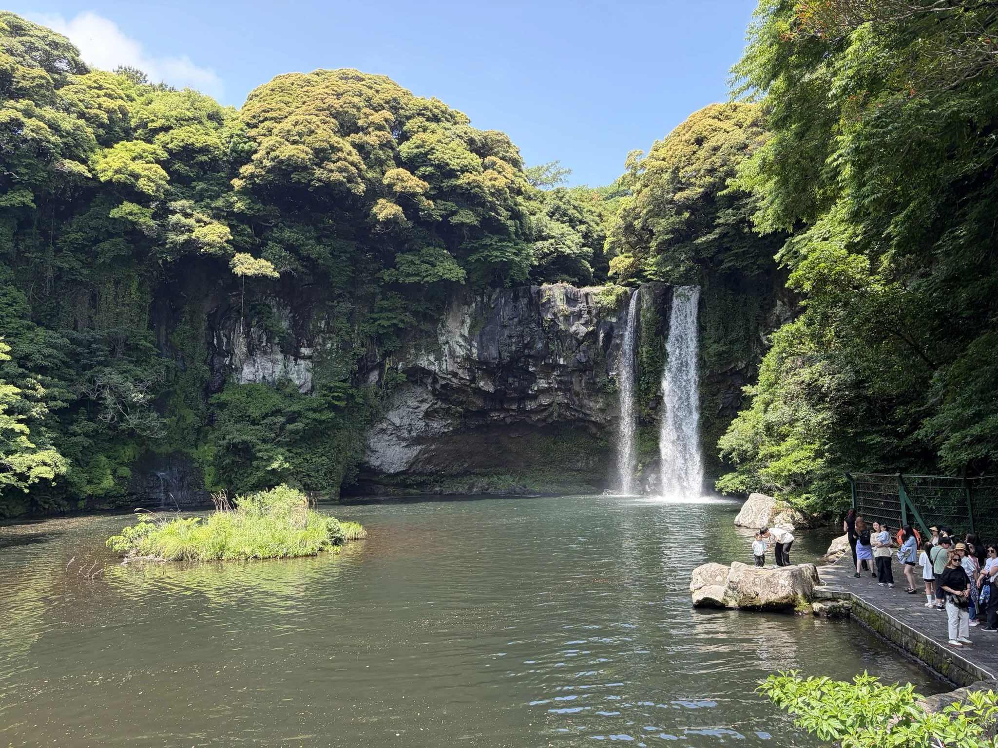Can you ever be bored with waterfalls? A lake surrounded by cliffs with a waterfall to one side while people look on