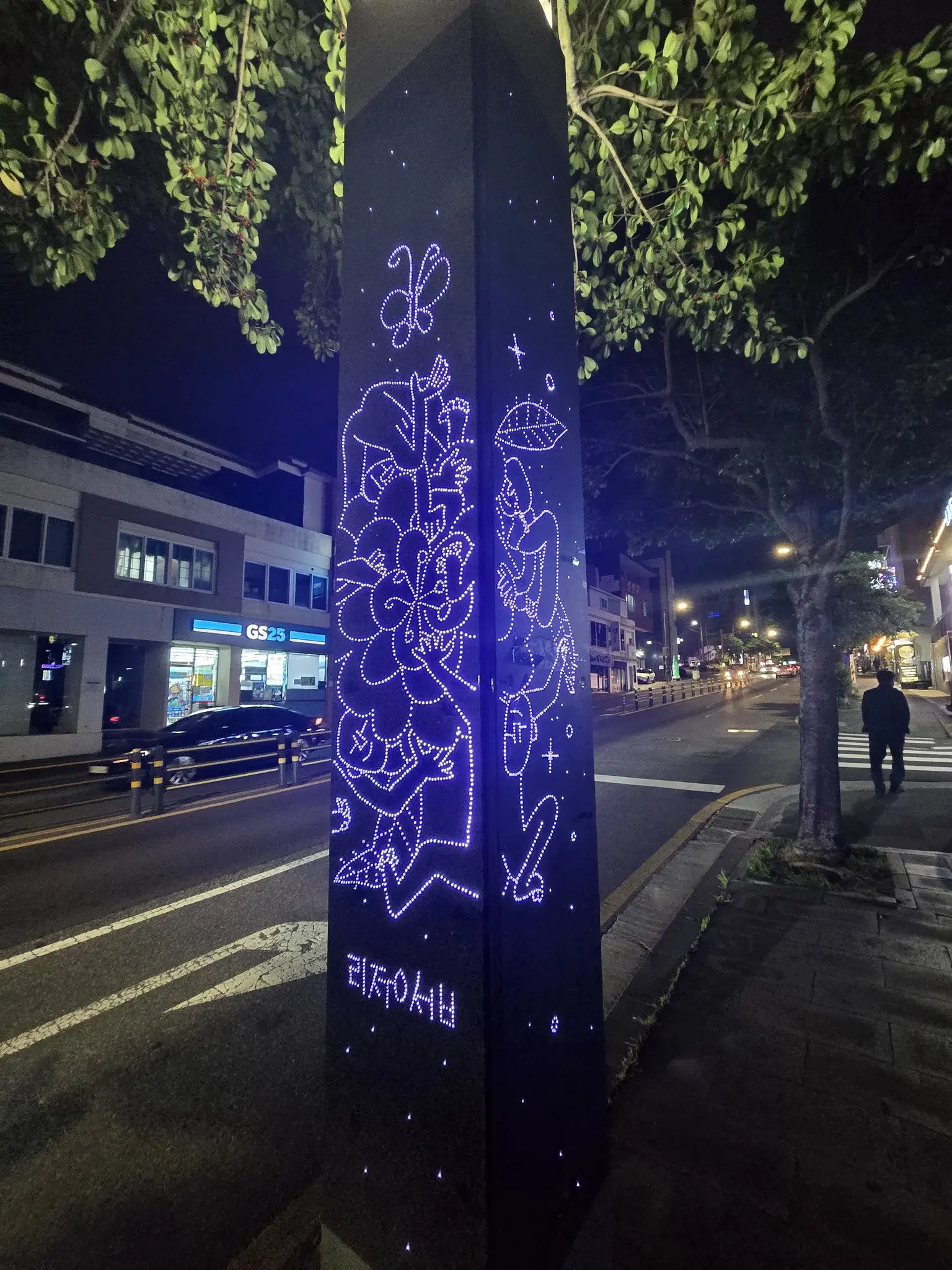 Beautiful signposts A metal post with a blue light inside it and holes drilled to display a picture of flowers and a man